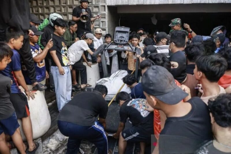 Sejumlah warga bergantian menyerahkan barang-barang yang mereka jarah di teras rumah Ahmad Sahroni. (Jennus)