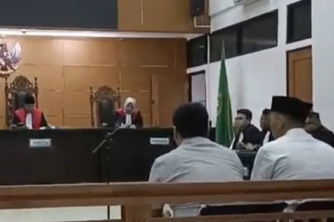Kepala Desa Kohod, Kecamatan Pakuhaji, Kabupaten Tangerang, Arsin, bersama tiga perangkat desa saat sidang di Pengadilan Negeri Serang, Selasa (30/9/2025). (Jennus)