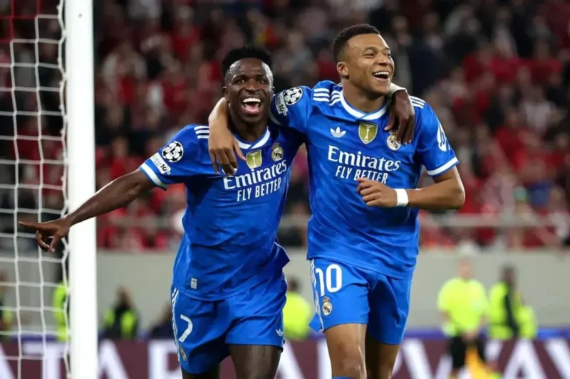 Selebrasi Kylian Mbappe dan Vinicius setelah mencetak gol untuk Real Madrid dalam pertandingan Liga Champions melawan Olympiakos di Karaiskakis Stadium pada Kamis (27/11/2025). (UEFA.com)