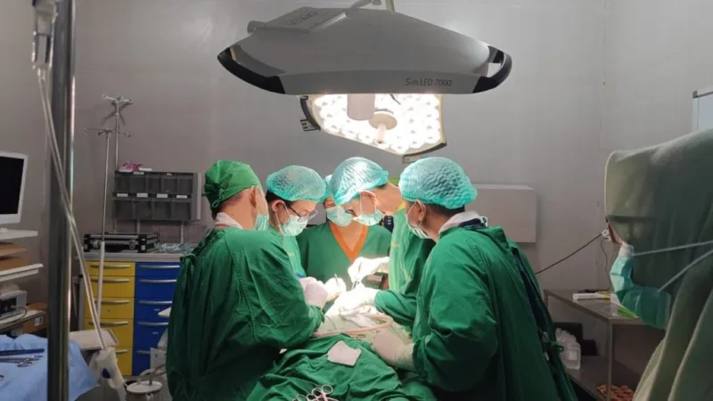 Tim Rescue Universitas Muhammadiyah Yogyakarta (UMY) 2025. melalukan tindakan medis kepada  seorang pasien kanker lidah stadium lanjut di lokasi pengungsian, Rabu (24/12/2025). (Dok UMY)