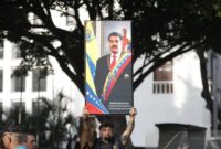 Seseorang melakukan demontrasi di depan Istana Miraflores di Caracas, ibu kota Venezuela, mengecam tindakan AS menangkap Presiden Nicolas Maduro dan membawanya ke luar negeri. (Str/Xinhua)