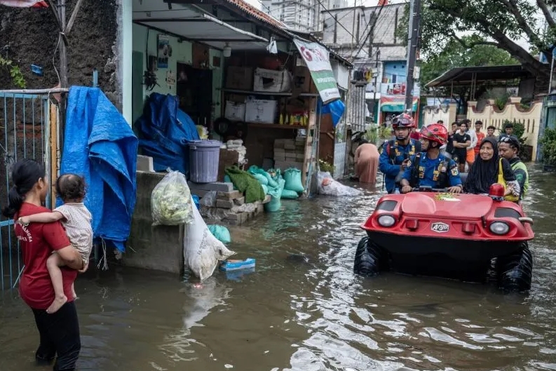 Petugas Suku Dinas Penanggulangan Kebakaran dan Penyelamatan (Gulkarmat) Jakarta Barat mengevakuasi warga yang terdampak banjir menggunakan kendaraan amfibi di Rawa Buaya, Cengkareng, Jakarta, Sabtu (24/1/2026). (Jennus)