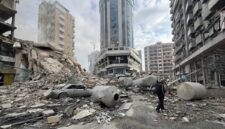 Seorang warga berjalan sendiri di atas tumpukan puing gedung yang hancur oleh serangan Israel di Beirut Selatan. (XInhua)