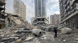 Seorang warga berjalan sendiri di atas tumpukan puing gedung yang hancur oleh serangan Israel di Beirut Selatan. (XInhua)