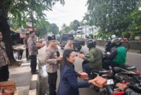 Anggota DPRD Kota Bekasi Yenni Kristianti bersama personel kepolisian turun ke jalan membagikan paket takjil kepada warga yang melintas di kawasan Kranji, Kamis (5/3/2026). (Dok Polsek)