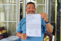 Kasno menunjukkan surat laporan yang disampaikannya ke Polres Metro Depok, Minggu (15/3/2026). (Istimewa)