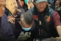Taufik Hidayat (di tengah mengenakan masker) digiring petugas Polda Jabar usai ditangkap di daerah Majalaya, Selasa (23/6/2026). (Jennus)