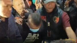 Taufik Hidayat (di tengah mengenakan masker) digiring petugas Polda Jabar usai ditangkap di daerah Majalaya, Selasa (23/6/2026). (Jennus)