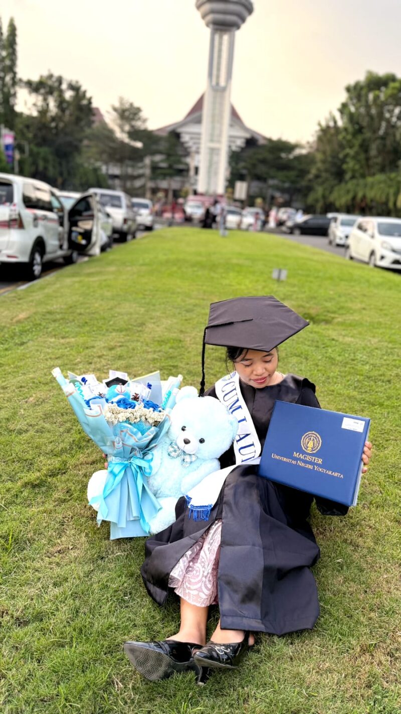 Ekspresi bahagia seorang lulusan S2 (Magister) Universitas Negeri Yogyakarta saat melihat map ijazah yang baru saja diterimanya pada hari kelulusan.
