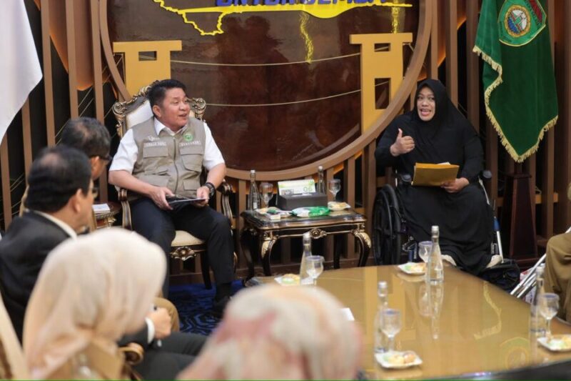 Potret Herman Deru yang tampak tersenyum ramah saat mendengarkan aspirasi dari perwakilan komunitas disabilitas.