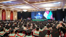 Kepala Badan Ekonomi Kreatif menyampaikan orasi ilmiah yang ditayangkan melalui layar besar di hadapan ratusan wisudawan