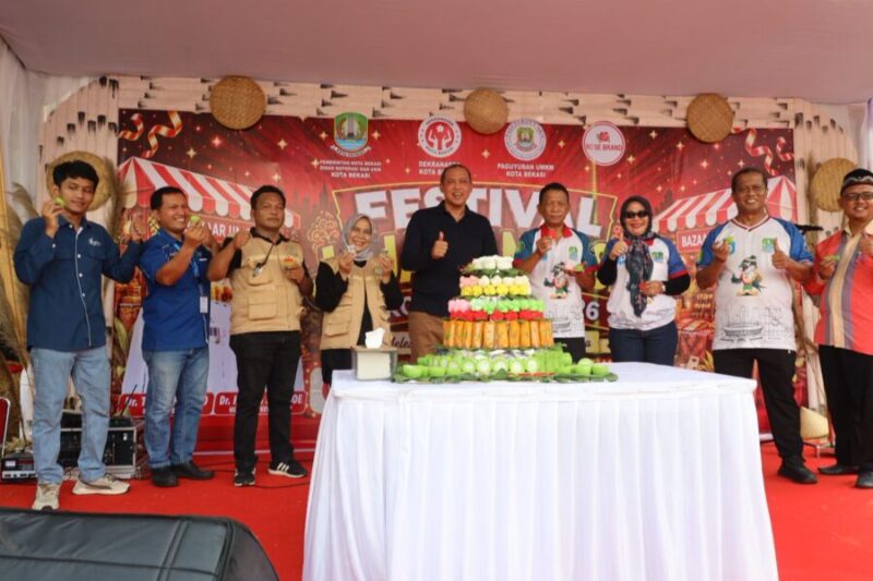 Tri Adhianto bersama jajaran perangkat daerah dan perwakilan paguyuban menunjukkan jajanan pasar tradisional saat menghadiri Festival Jajanan Pasar di Kota Bekasi
