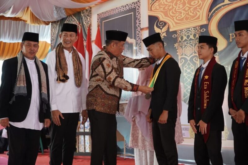 H. Cik Ujang mengalungkan medali wisuda kepada santri dalam prosesi Haflah Akhirussanah Pondok Pesantren Al-Rozi di Desa Sedupi