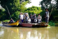 warga bersama sepeda motor mereka menaiki perahu penyeberangan tradisional saat melintasi aliran Way Bungur di Kecamatan Way Bungur, Kabupaten Lampung Timur  