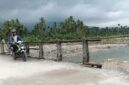 Seorang warga melintasi jembatan darurat di Nagari Anduriang, Kecamatan 2x11 Kayu Tanam, Kabupaten Padang Pariaman, Sumatera Barat
