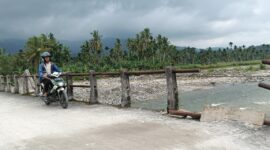 Seorang warga melintasi jembatan darurat di Nagari Anduriang, Kecamatan 2x11 Kayu Tanam, Kabupaten Padang Pariaman, Sumatera Barat