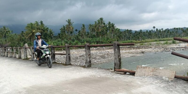 Seorang warga melintasi jembatan darurat di Nagari Anduriang, Kecamatan 2x11 Kayu Tanam, Kabupaten Padang Pariaman, Sumatera Barat
