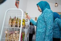 Ketua TP PKK Provinsi Sumatera Selatan melihat dan memilih produk makanan kemasan hasil karya kader PKK saat meresmikan Warung PKK Kota Lubuk Linggau  