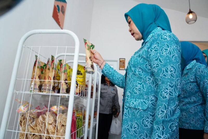 Ketua TP PKK Provinsi Sumatera Selatan melihat dan memilih produk makanan kemasan hasil karya kader PKK saat meresmikan Warung PKK Kota Lubuk Linggau  
