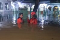 Para petugas Badan Penanggulangan Bencana Daerah (BPBD) terjun ke aliran banjir di wilayah Pasuruan, Jawa Timur, saat musim hujan tahun 2025. (Facebook)