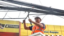 Tri Adhianto memotong jaringan kabel udara fiber optik yang semrawut di salah satu ruas jalan utama Kota Bekasi