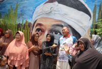 Tri Adhianto, bercengkerama dengan warga di depan lukisan mural khas Pasundan saat melakukan tinjauan lapangan di RW 14, Kelurahan Pekayon Jaya, Kecamatan Bekasi Selatan.