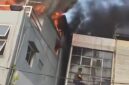 Demi menyelamatkan anaknya yang masih kecil, seorang ibu menerobos kobaran api dan membawa sang anak keluar melalui bangunan di sebelah rumah makan yang terbakar. (Tangkapan layar video amatir)