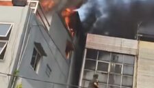 Demi menyelamatkan anaknya yang masih kecil, seorang ibu menerobos kobaran api dan membawa sang anak keluar melalui bangunan di sebelah rumah makan yang terbakar. (Tangkapan layar video amatir)