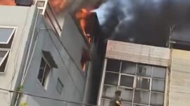 Demi menyelamatkan anaknya yang masih kecil, seorang ibu menerobos kobaran api dan membawa sang anak keluar melalui bangunan di sebelah rumah makan yang terbakar. (Tangkapan layar video amatir)